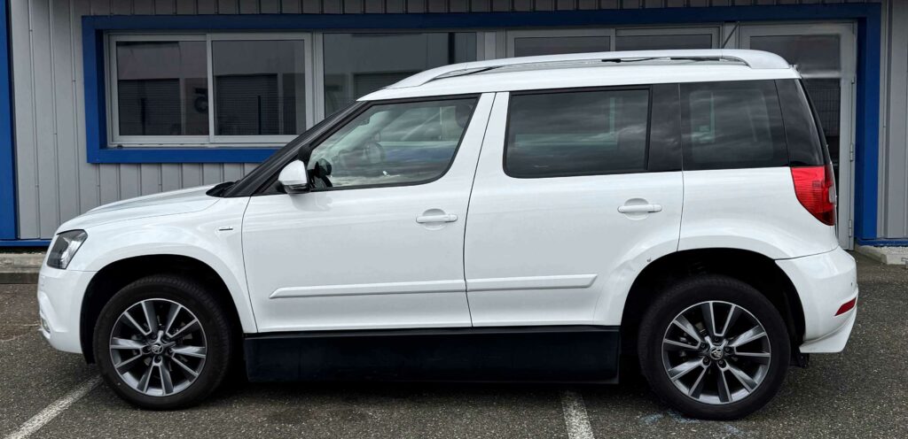 Skoda Yéti blanc de 2017 aménagé conduite en fauteuil avec joystick par ACA à vendre, photo prise depuis l'arrière du véhicule avec le hayon du coté gauche du véhicule