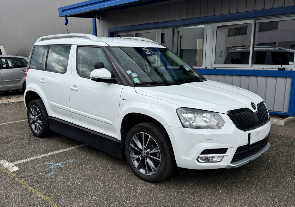 Skoda Yéti blanc de 2017 aménagé conduite en fauteuil avec joystick par ACA à vendre, photo de l'avant et du côté droit.