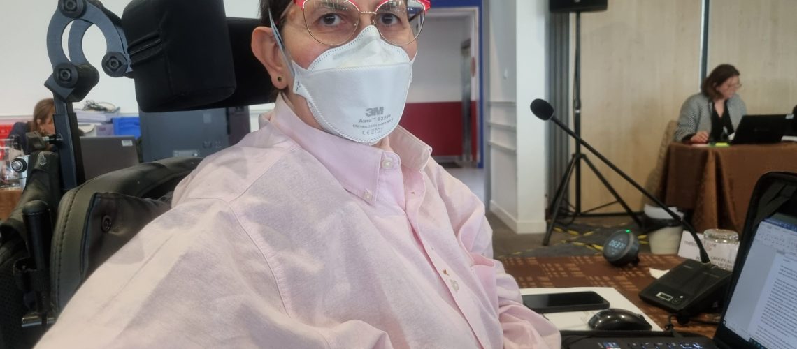 Odile Maurin lors du conseil de la métropole du 8 février 2024 aux espaces Vanel à Toulouse - photo du haut du corps dans son fauteuil avec une chemise rose et un masque FFP2